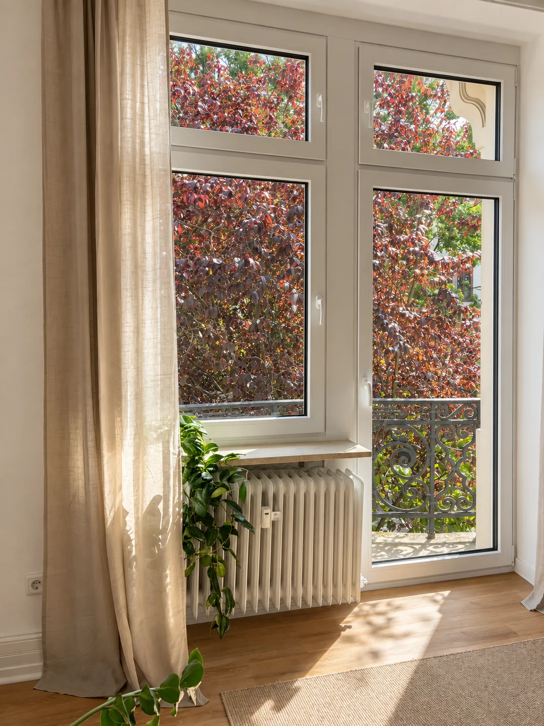 Fenster mit Leinenvorhang und Blick ins Grüne